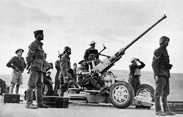 Greek soldiers stand by an a gun, manned by British soldiers