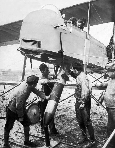 Ground crew fit the tail vanes and manoeuvre a bomb into the bomb bay of a French Air