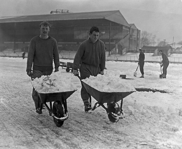 Grounds staff at Bristol Rovers Eastville Stadium struggle to clear snow from the pitch