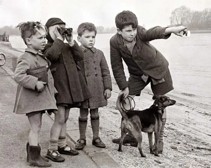 Framed Print : A group of children look to the distance using a pair of binoculars