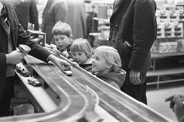 A group of children look on longingly at the latest Scalextric slot car racing set in