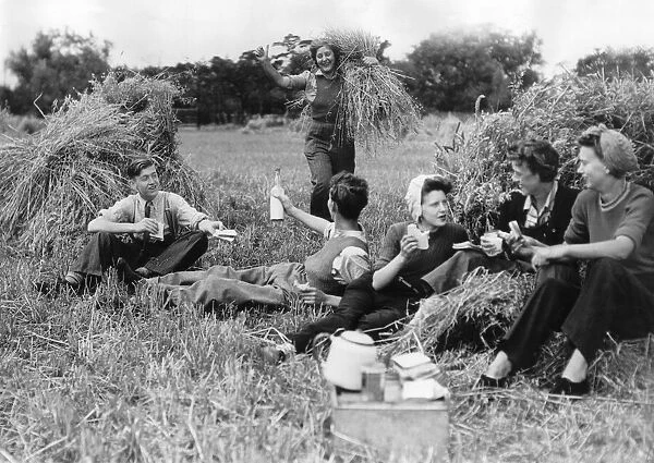 A group of friends enjoy a picnic out in the countryside during their farm holiday at