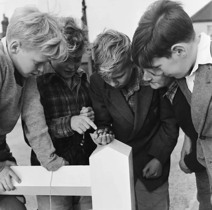 Framed Print : A group of friends taking part in a game of conkers outside their house Framed Print : A group of friends taking part in a game of conkers outside their house