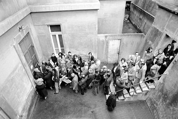 A group of people queuing to enter a building in a suburb on the outskirts of Rome