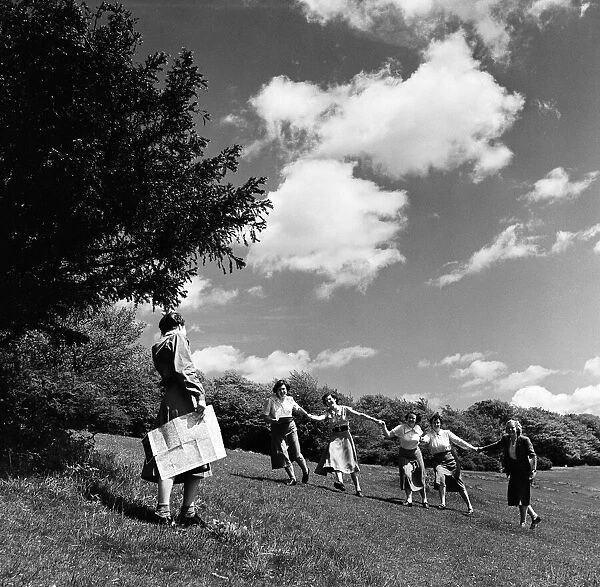 A group of women holding hands as they walk on Box Hill, Surrey. June 1952