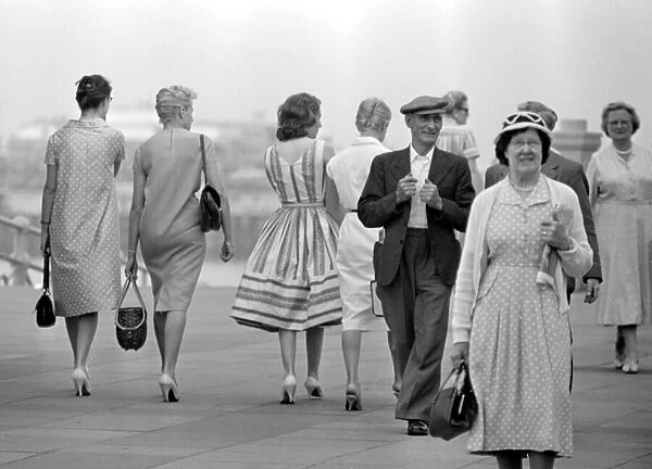 A group of women walk along the seafront at Brighton July 1958