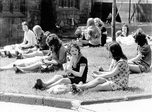 A group of young women enjoying the sun, on the grass at St