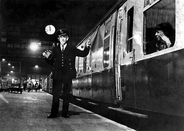 A guard signals to the driver that the train can depart the station