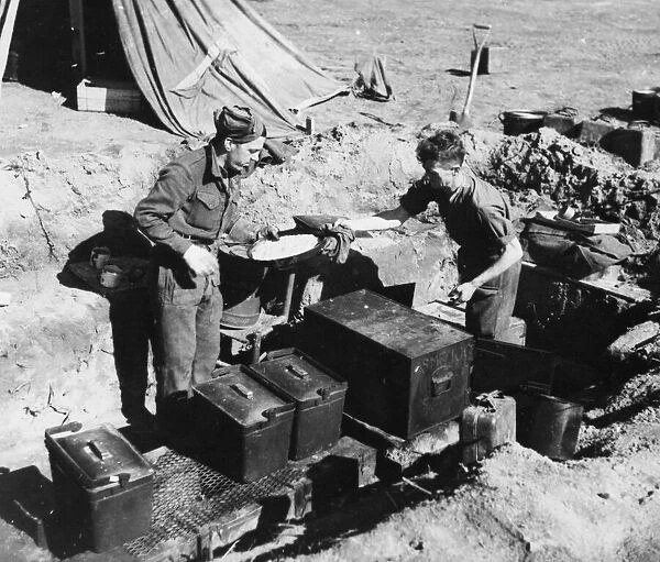 Gunner James Pearson and Gunner E. L. Shaw cook for the troops in the Anzio beach head