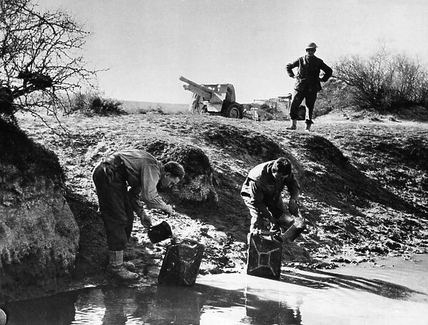 Gunners fill up their cans at a desert water-hole, had their first wash for days