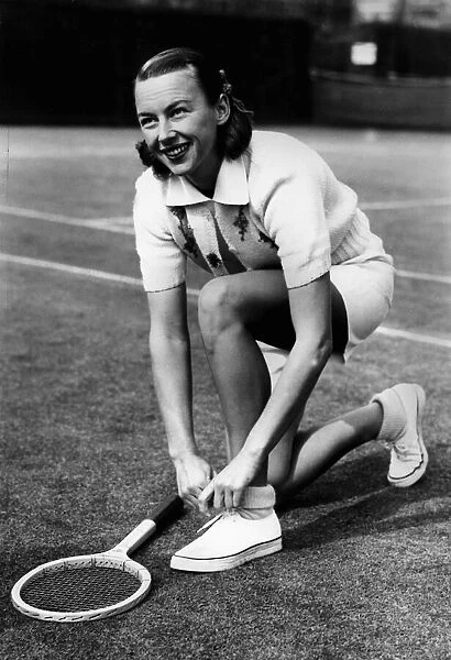 Gussie Moran playing tennis at Queens Club September 1949 adjusting her