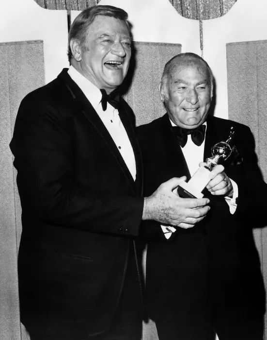 Framed Print : Hal Wallis film producer accepts Cecil B De Mille award 1975 from actor John Wayne