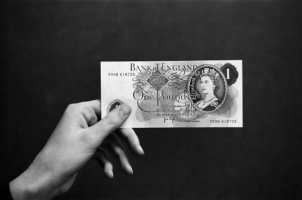 A hand holding a pound note. 14th February 1974