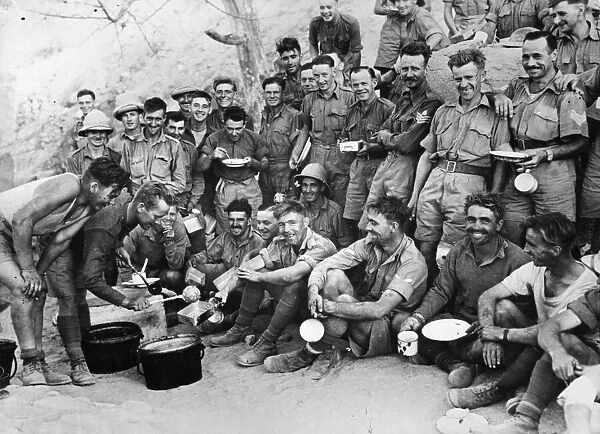 A happy group of British soldiers awaiting their turn for food at a meal parade in