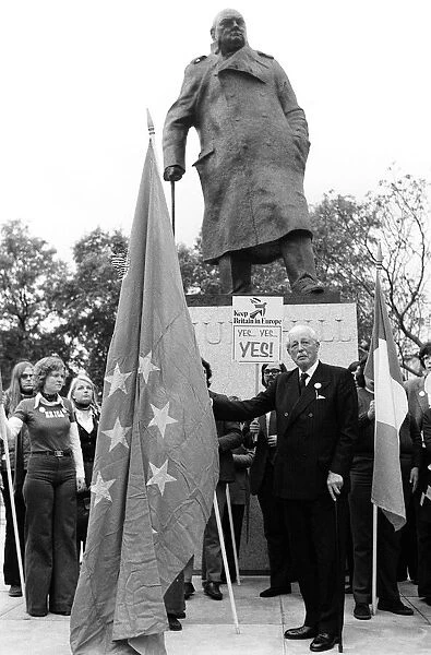 Harold MacMillan March 1975 holding the European flag under the statue of Sir Winston