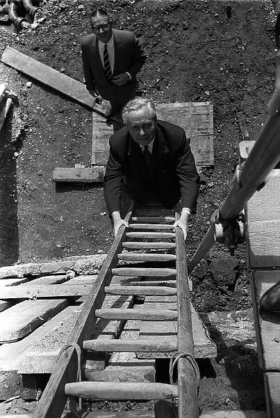 Harold Wilson climbs a builders ladder during a visit to Toynbee Hall in the procsess