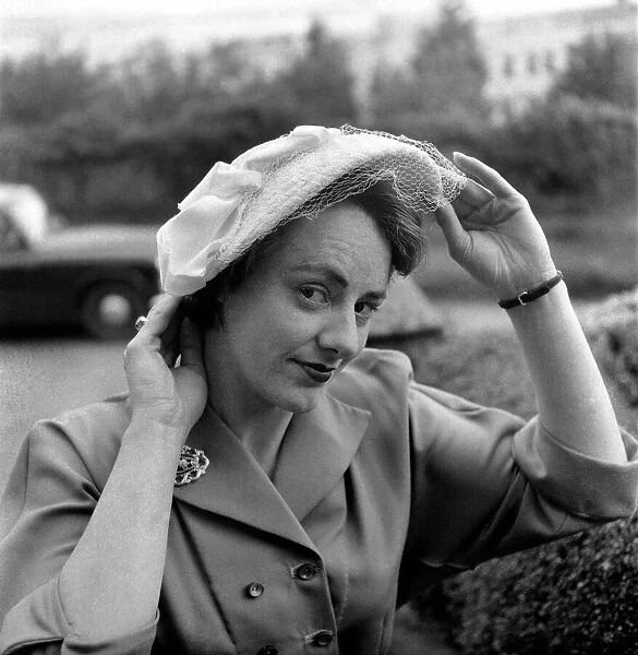 Hat Fashions 1953. Woman adjusts hat. May 1953 D2613