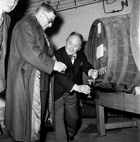 Hector Hughes, Q. C. pours out a glass of sherry out of one of the large barrels for one
