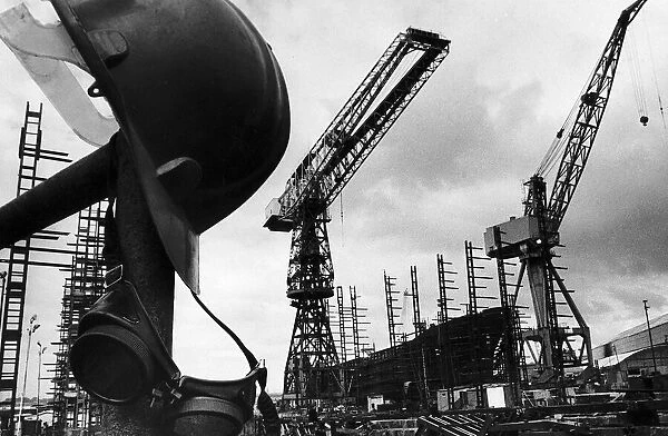 A helmet hanging with welders goggles amongst the empty cranes after the closure of Govan