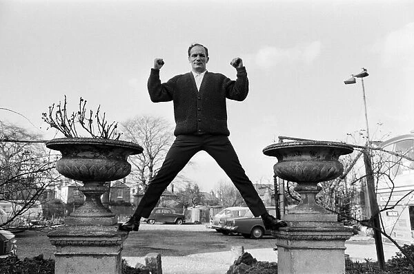 Henry Cooper, pictured standing astride two ornamental flower pots in the garden of The
