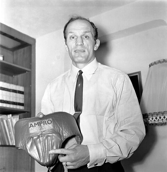 Henry Cooper showing the damage to his ampro bodyguard which was caused by low blows