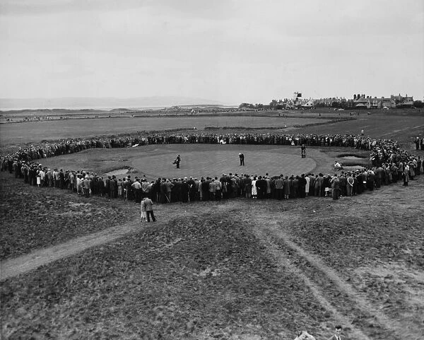 Henry Cotton, watched by a large crowd, holing out at the 16th hole during the 1956 Open