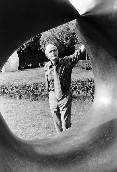 Henry Moore Artist Sculptor looks through one of his sculptures. 1978