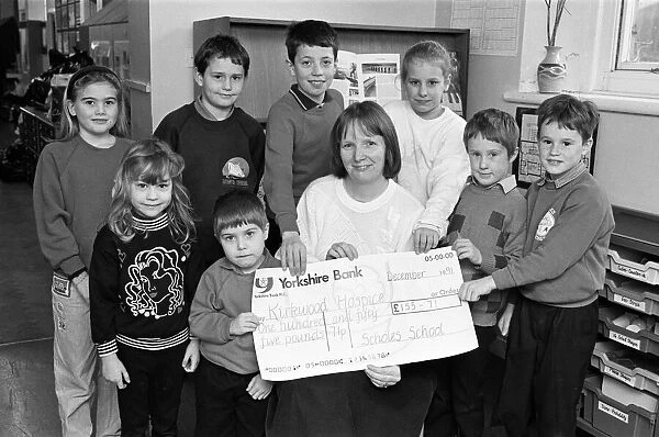 Hilary Turner of Kirkwood Hospice receives £155. 75 cheque from children at Scholes