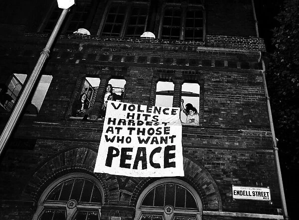 Hippies with banner hanging from window before police arrived to evict them from their