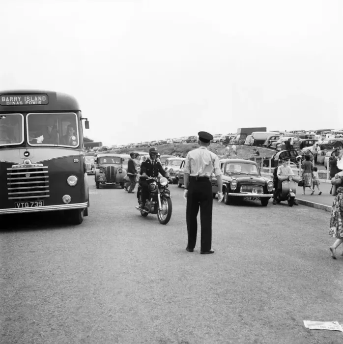 Framed Print : Holiday Crowds at Barry Island: Two Barry policeman control the dangerous crossing point Framed Print : Holiday Crowds at Barry Island: Two Barry policeman control the dangerous crossing point