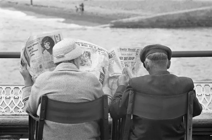 Framed Print : Holiday scenes at Brighton. Elderly couple reading the Daily Herald on Brighton
