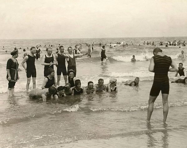 Holidaymaker taking a photograph of his friends bathing in the sea at Norderney