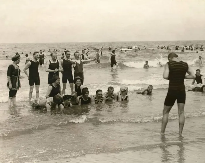 Framed Print : Holidaymaker taking a photograph of his friends bathing in the sea at Norderney