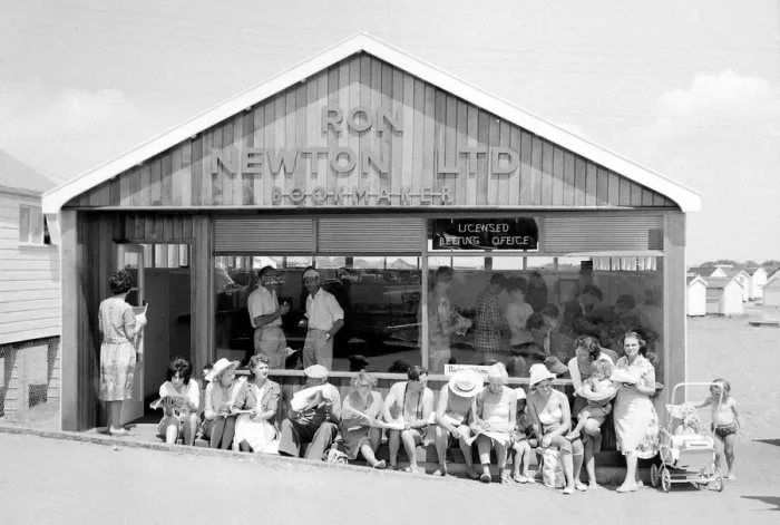 Framed Print : Holidaymakers enjoy the sunshine as they sit outside a betting shop in the form of a Framed Print : Holidaymakers enjoy the sunshine as they sit outside a betting shop in the form of a