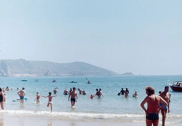 Holidaymakers and locals enjoy a day out on the beach on the Channel Island of Jersey