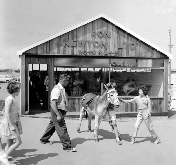Framed Print : Holidaymakers outside a betting shop in the form of a wooden chalet on the beach Framed Print : Holidaymakers outside a betting shop in the form of a wooden chalet on the beach