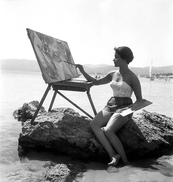 Holidays Carmen Lacano seen here painting a seaside view from the rocks wearing her