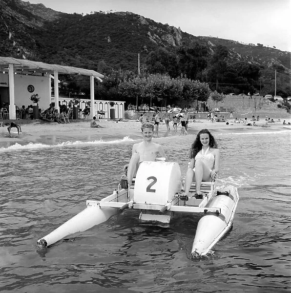 Holidays: Couple riding on a pedalo off the coast of Corsica. August 1957