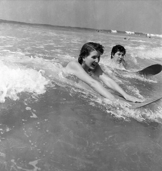 Holidays. Two shop assistants surfing at newquay, Cornwall. May 1953 D2386