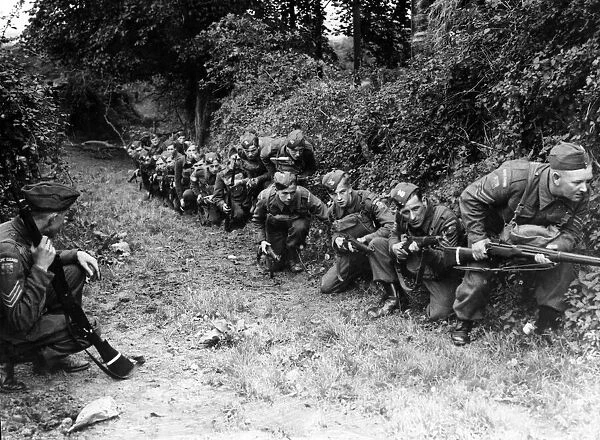 Home Guard camp near Cardiff. Men use the cover of a hedge before advancing against