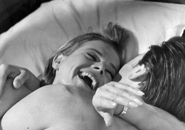 Honor Blackman laughing in bed with Laurence Harvey during filming of Life at the Top