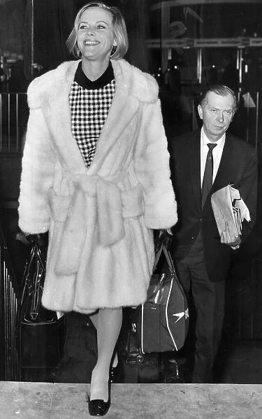 Honor Blackman wearing white fur coat at London airport - January 1968