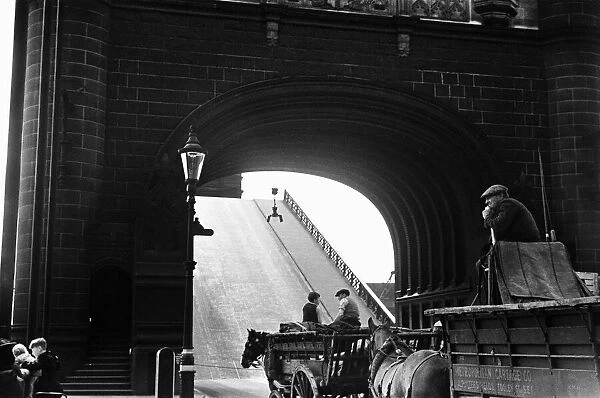 Horse drawn carts wait whilst Tower Bridge is raised Circa August 1936