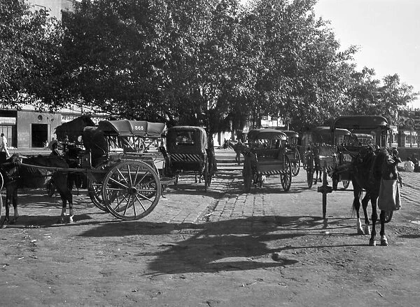 Horse - drawn taxis seen here waiting outside Poonah railway station. April 1959