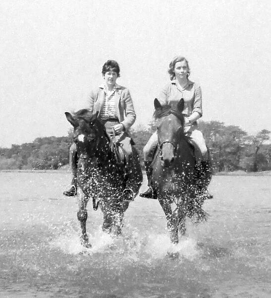 Horse riders splash through Powells Pool, near the Boldmere entrance of Sutton Park