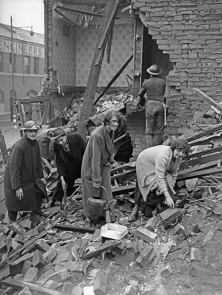 Householders search through the remains of their bombed home, searching for belongings