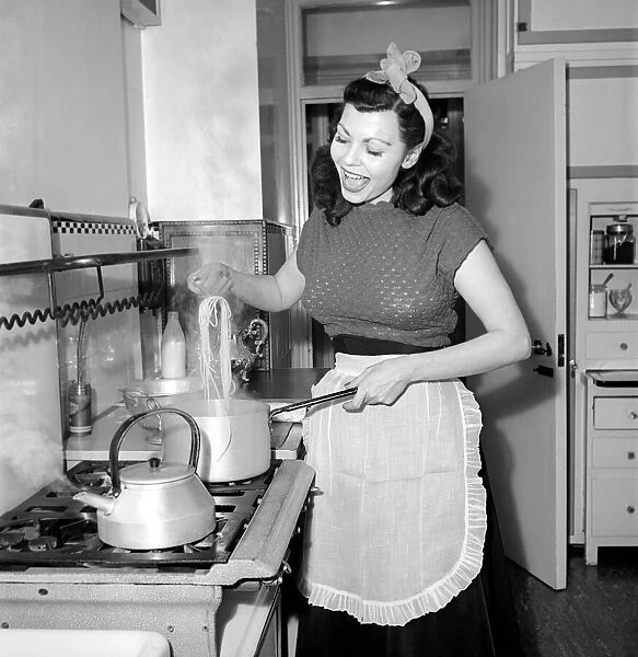 A Housewife cooking spaghetti in the kitchen, 1957