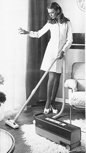 A housewife spring cleaning her lounge with a vacuum cleaner