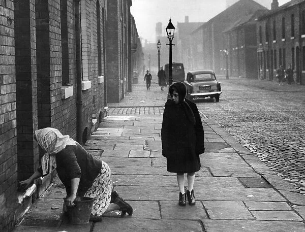 A housewife stoning the steps in Nelson Street, Manchester. 1st December 1961
