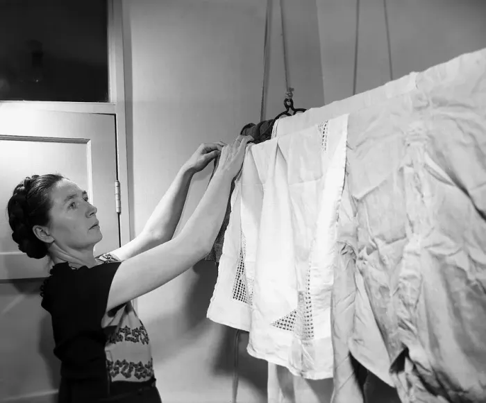 Framed Print : Housewives Washing Controversy A woman hangs up her laundry to dry in her North